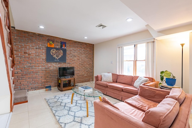 tiled living room featuring brick wall