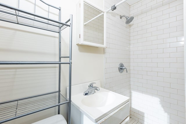 bathroom featuring sink and a tile shower