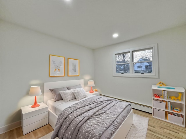 bedroom featuring light hardwood / wood-style flooring and a baseboard radiator