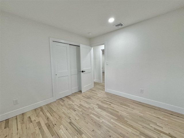 unfurnished bedroom featuring a closet and light hardwood / wood-style flooring