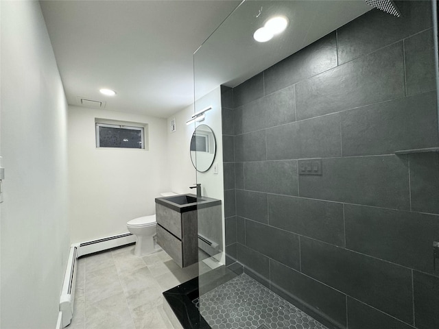 bathroom with tiled shower, vanity, toilet, and a baseboard heating unit