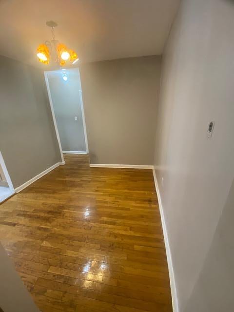 unfurnished dining area featuring dark hardwood / wood-style flooring and an inviting chandelier