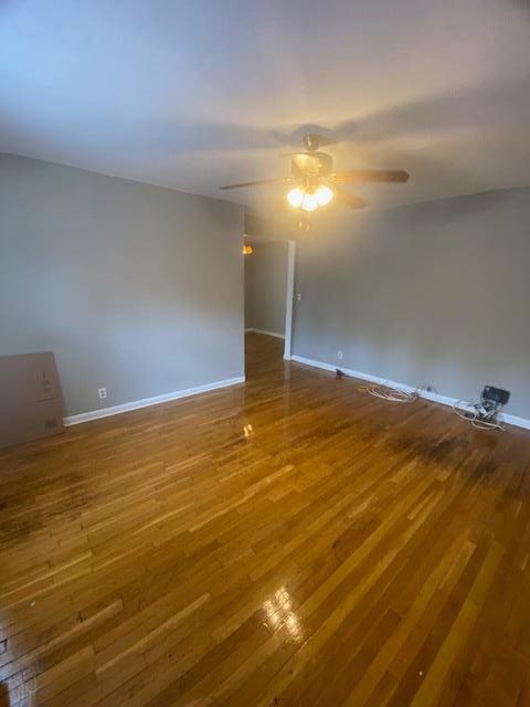 empty room with hardwood / wood-style floors and ceiling fan