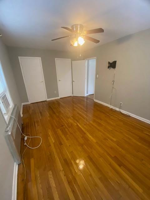 empty room with ceiling fan and hardwood / wood-style floors