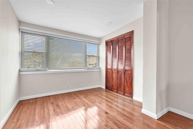 unfurnished bedroom featuring a closet and light wood-type flooring