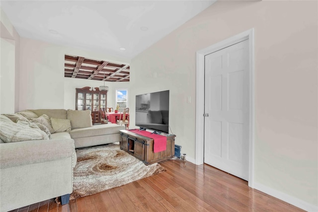 living room with coffered ceiling, hardwood / wood-style flooring, and beamed ceiling