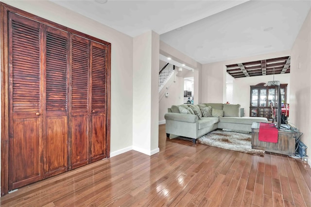 living room with coffered ceiling, beam ceiling, and wood-type flooring