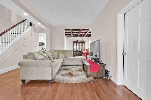 living room with hardwood / wood-style flooring, coffered ceiling, and beam ceiling