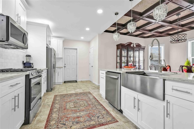 kitchen featuring white cabinetry, appliances with stainless steel finishes, coffered ceiling, and decorative light fixtures