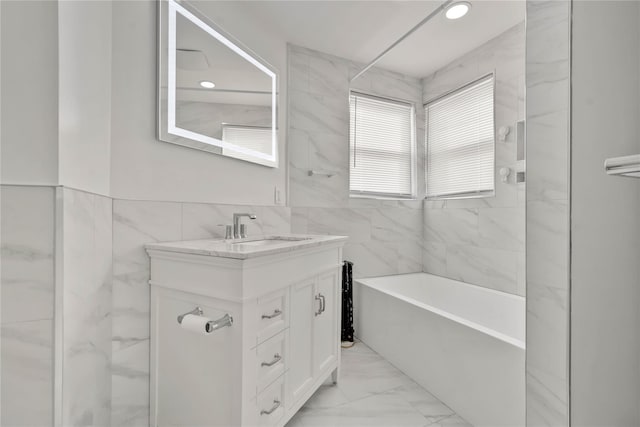 bathroom with tile walls, vanity, and  shower combination