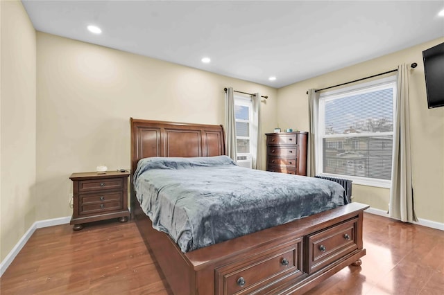 bedroom featuring radiator heating unit and dark hardwood / wood-style flooring