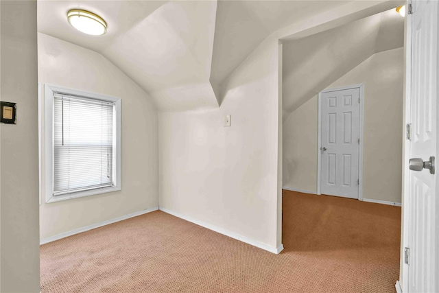 bonus room with vaulted ceiling and light carpet