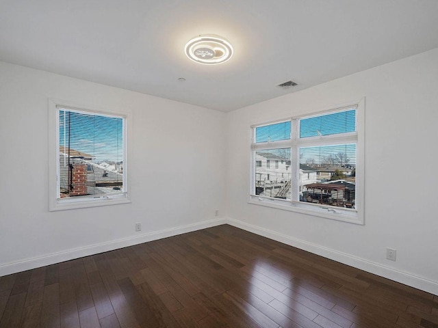 empty room with dark hardwood / wood-style flooring