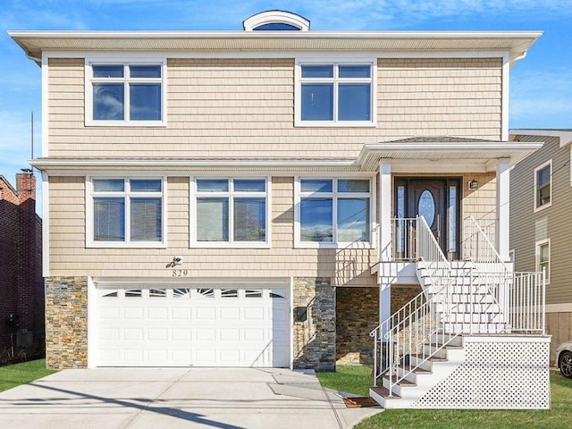 view of front of property featuring stone siding, a garage, and concrete driveway