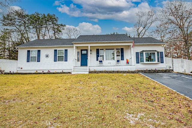 ranch-style home featuring a porch and a front lawn