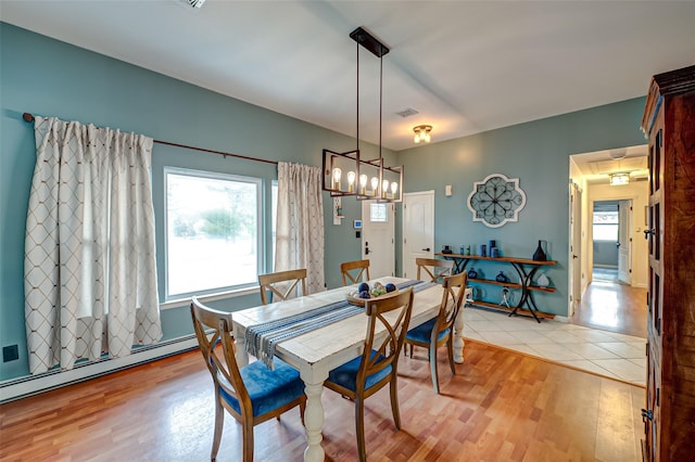 dining area featuring light hardwood / wood-style floors and a baseboard heating unit