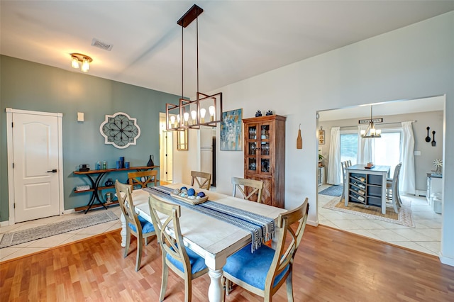 tiled dining space with a chandelier