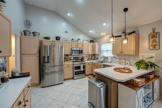 kitchen with pendant lighting, light tile patterned floors, sink, appliances with stainless steel finishes, and light brown cabinetry