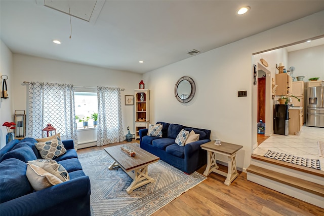 living room with a baseboard radiator and light hardwood / wood-style flooring