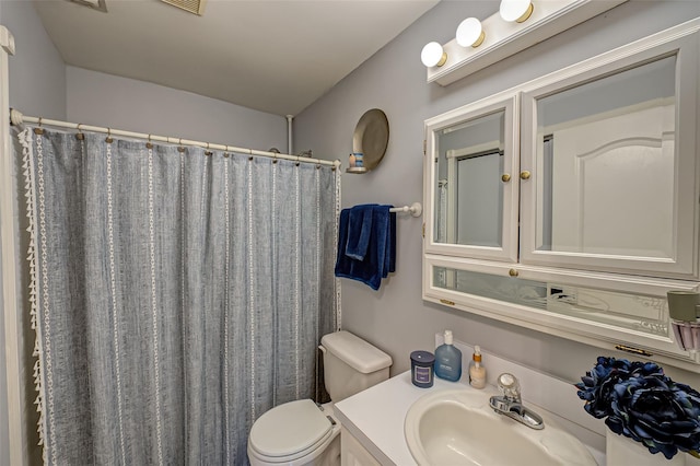 bathroom featuring a shower with curtain, vanity, and toilet