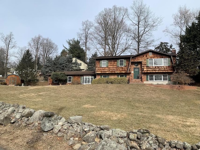 view of front of house with a shed and a front lawn