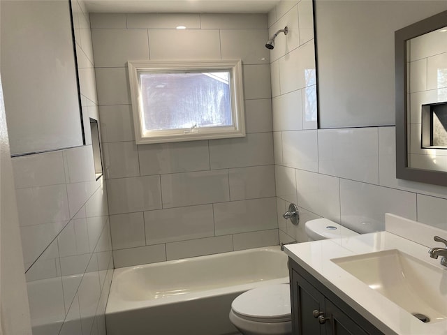 full bathroom featuring tiled shower / bath combo, vanity, tile walls, and toilet