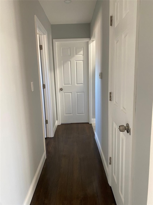 hallway with dark hardwood / wood-style flooring