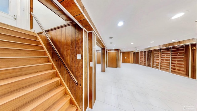 stairs featuring wood walls