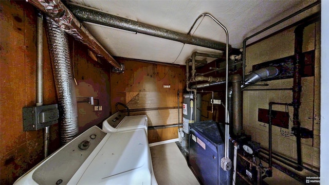 interior space featuring water heater, washing machine and dryer, and wood walls