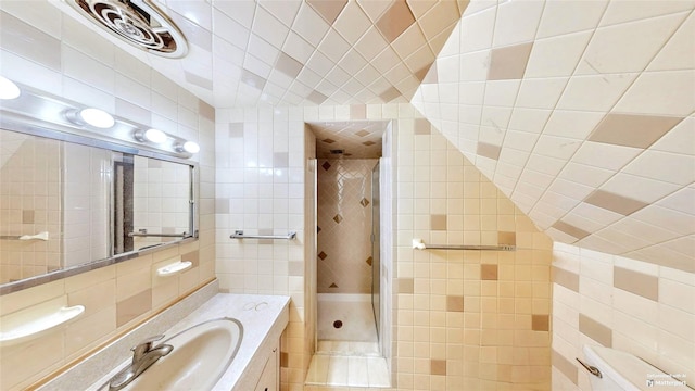 bathroom featuring tile walls, vanity, and walk in shower