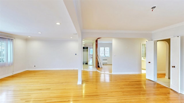 unfurnished room with ornamental molding and light wood-type flooring