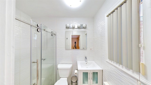 bathroom featuring a shower with shower door, tile walls, decorative backsplash, vanity, and toilet