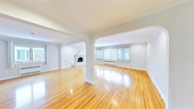 unfurnished living room with radiator, crown molding, and light hardwood / wood-style flooring