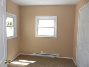 empty room featuring a wealth of natural light and baseboard heating