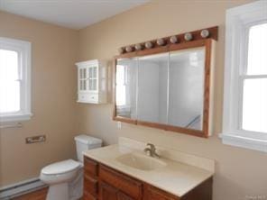 bathroom with a baseboard radiator, vanity, and toilet