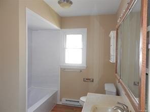 bathroom featuring vanity, a baseboard heating unit, and toilet