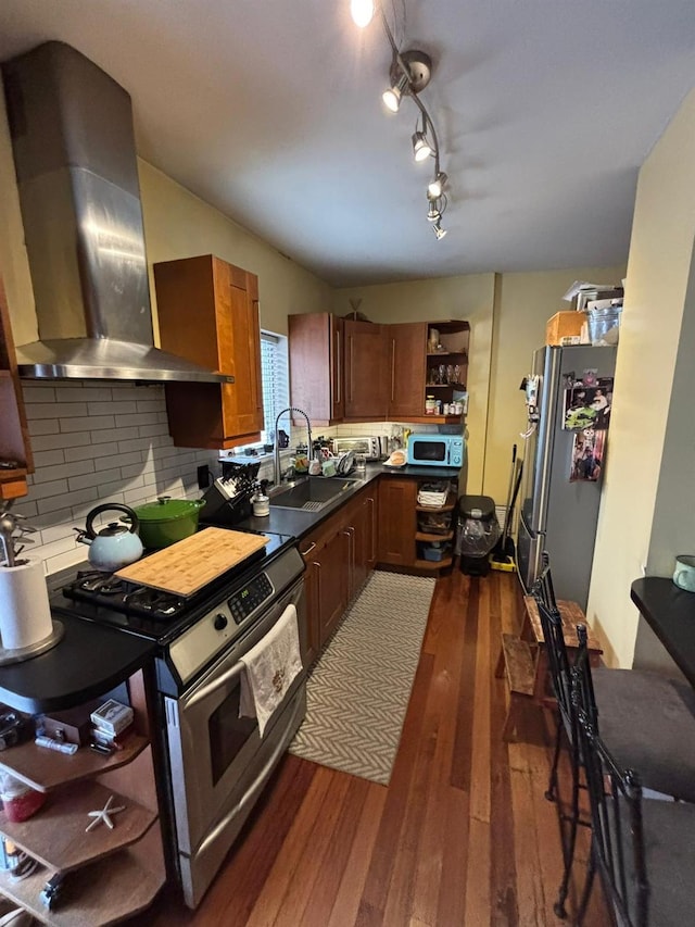 kitchen featuring tasteful backsplash, sink, stainless steel appliances, dark wood-type flooring, and wall chimney exhaust hood