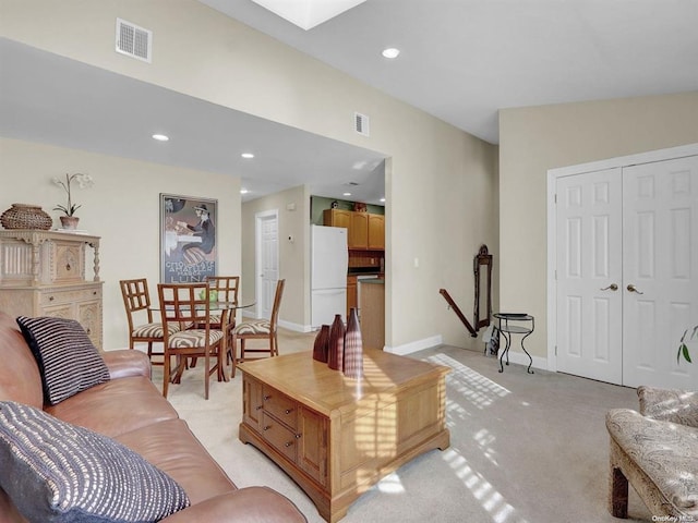 living room with light colored carpet and a skylight