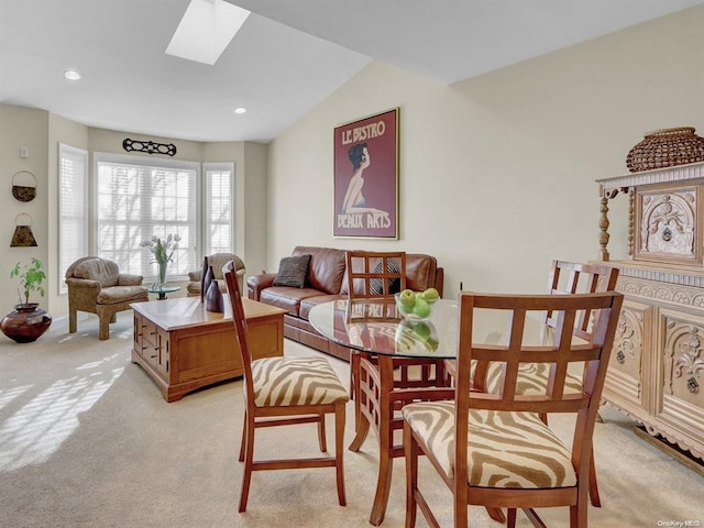 carpeted living room featuring lofted ceiling with skylight