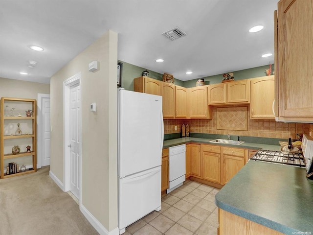 kitchen with light brown cabinetry, sink, white appliances, and tasteful backsplash