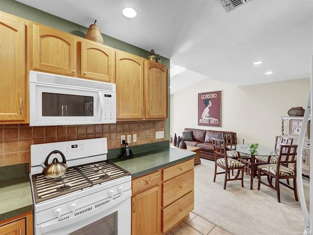 kitchen featuring tasteful backsplash, white appliances, light brown cabinets, and light tile patterned floors