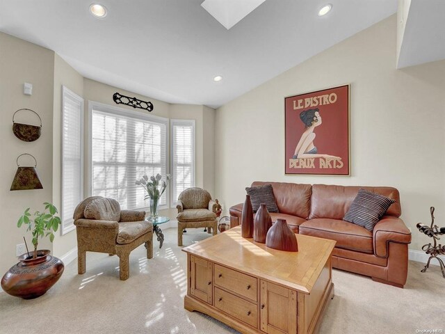 carpeted living room featuring lofted ceiling with skylight