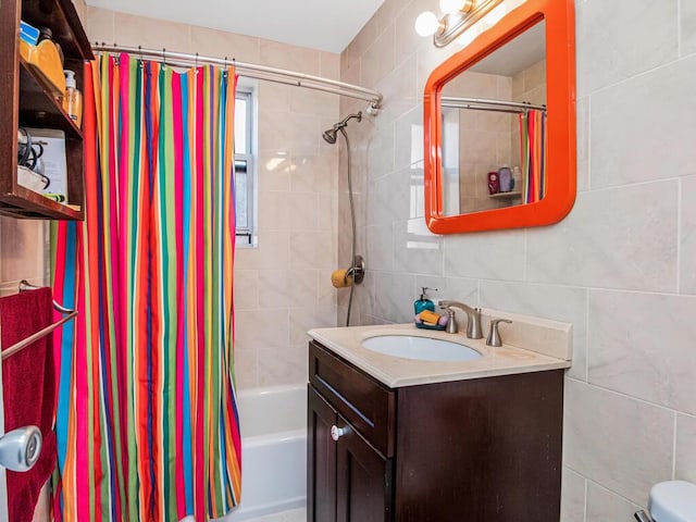 full bathroom featuring shower / tub combo with curtain, vanity, toilet, and tile walls