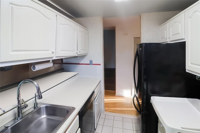 kitchen with sink, dishwasher, white cabinets, and black fridge