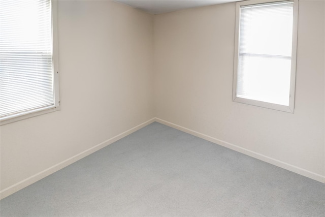 carpeted empty room featuring a wealth of natural light