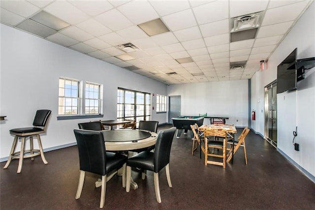 dining area featuring a drop ceiling and elevator