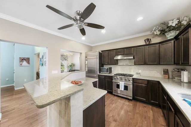 kitchen with light stone counters, stainless steel appliances, a center island, and light wood-type flooring