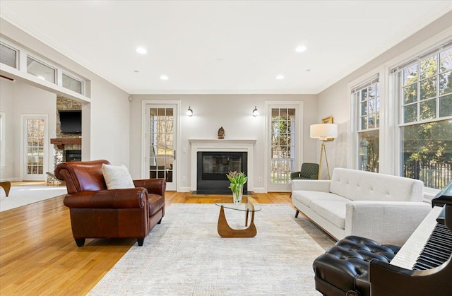 699 Ardsley Rd, Scarsdale, NY 10583 - living room featuring a glass covered fireplace, plenty of natural light, light wood-type flooring, and ornamental molding