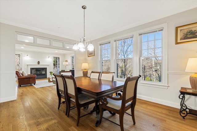699 Ardsley Rd, Scarsdale, NY 10583 - dining room with crown molding, wood finished floors, baseboards, and a glass covered fireplace