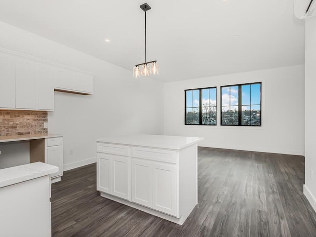 kitchen with hanging light fixtures, an AC wall unit, white cabinets, and dark hardwood / wood-style flooring